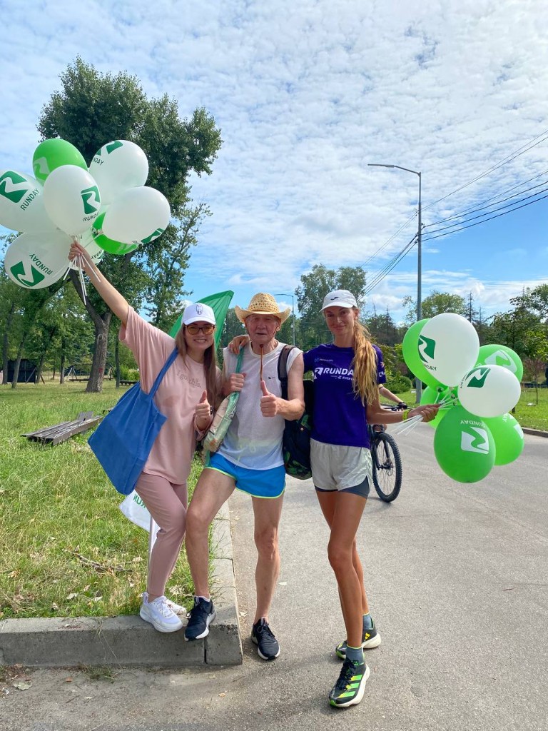 Happy organisers and runners with community run balloons